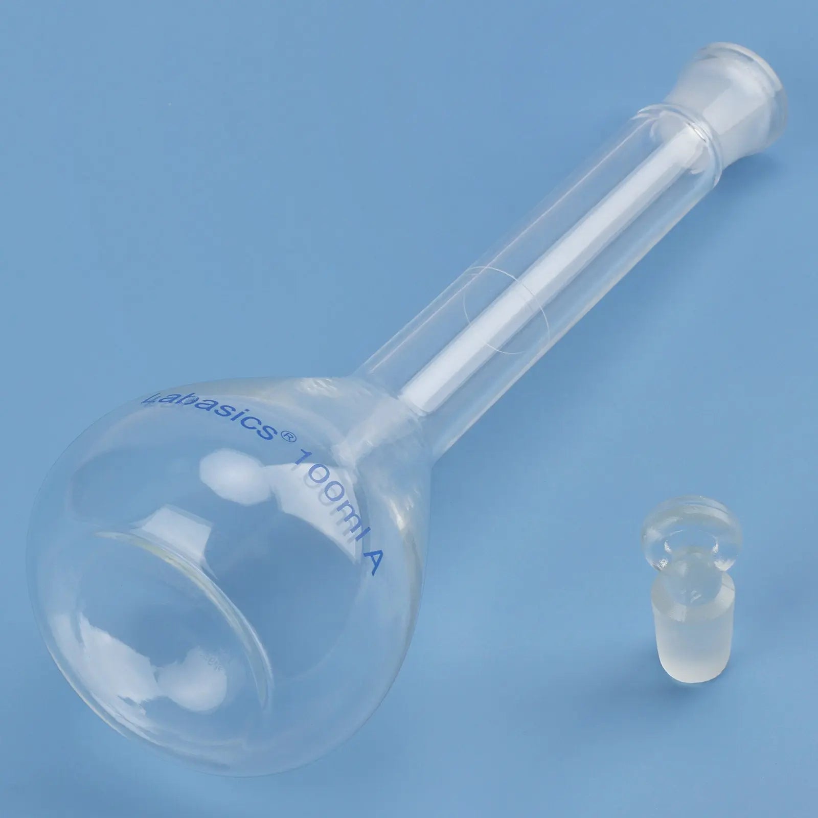 Flat bottom detail of clear 100 ml glass volumetric flask, durable borosilicate glass